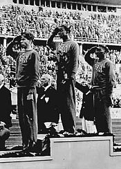 حقق فريق الولايات المتحدة في رياضة الوثب العالي فوزًا ساحقًا في منافسات الأولمبياد. من اليسار إلى اليمين: ديلوس ثوربر (برونزية)، كورنيليس جونسون (ذهبية)، وديفيد ألبرتون (فضية). حقق جونسون رقمًا قياسيًا في الأولمبياد حيث قام بتخطي الحاجر لمسافة 6 أقدام، 8 بوصات. 2 أغسطس، 1936.