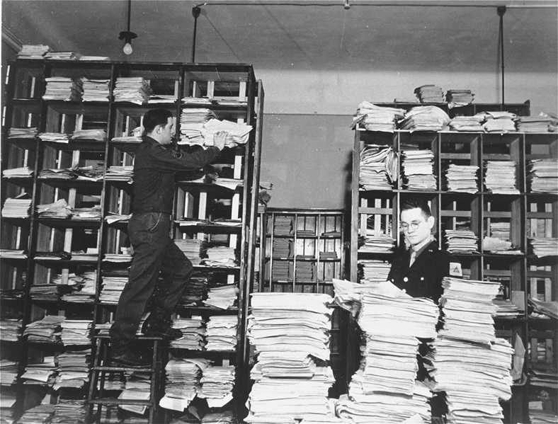 U.S. Army staffers organizing stacks of German documents collected by war crimes investigators as evidence for the International Military Tribunal.