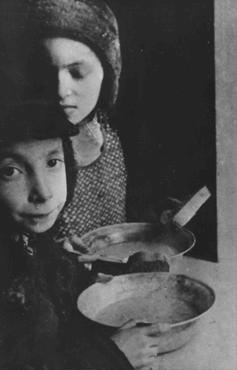 Crianças judias com tigelas de sopa no gueto de Varsóvia. Varsóvia, Polônia, por volta de 1940.