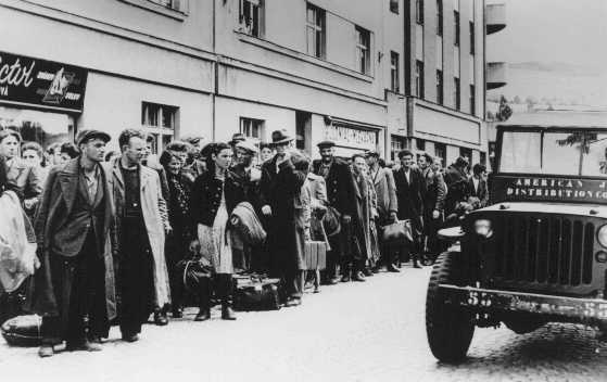 Jewish refugees who fled Poland as part of the postwar mass flight of Jews from eastern Europe (the Brihah) line the streets outside a reception center. Nachod, Czechoslovakia, July 1946.