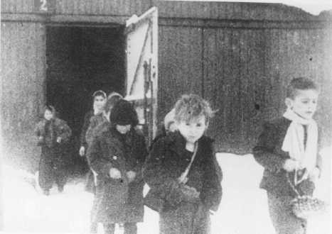 Poco después de su liberación, niños sobrevivientes de Auschwitz caminan fuera de sus barracas. Polonia, posterior al 27 de enero de 1945.