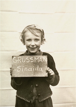 دختری در مرکز کودکان "کلوستر ایندرسدورف" (Kloster Indersdorf)، که از او عکس گرفته شده تا به این ترتیب، در یافتن خویشاوندان بازمانده اش به او کمک شود. چنین عکس هایی از کودکان یهودی و غیر یهودی در روزنامه ها چاپ می شد تا موجب تسهیل در دوباره به هم رساندن خانواده ها بشود. آلمان، پس از ماه مه 1945.
