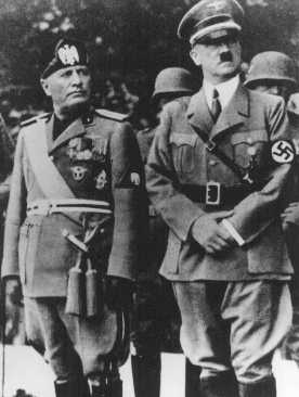Benito Mussolini and Adolf Hitler stand together on an reviewing stand during a official visit to occupied Yugoslavia, 1941-1943.