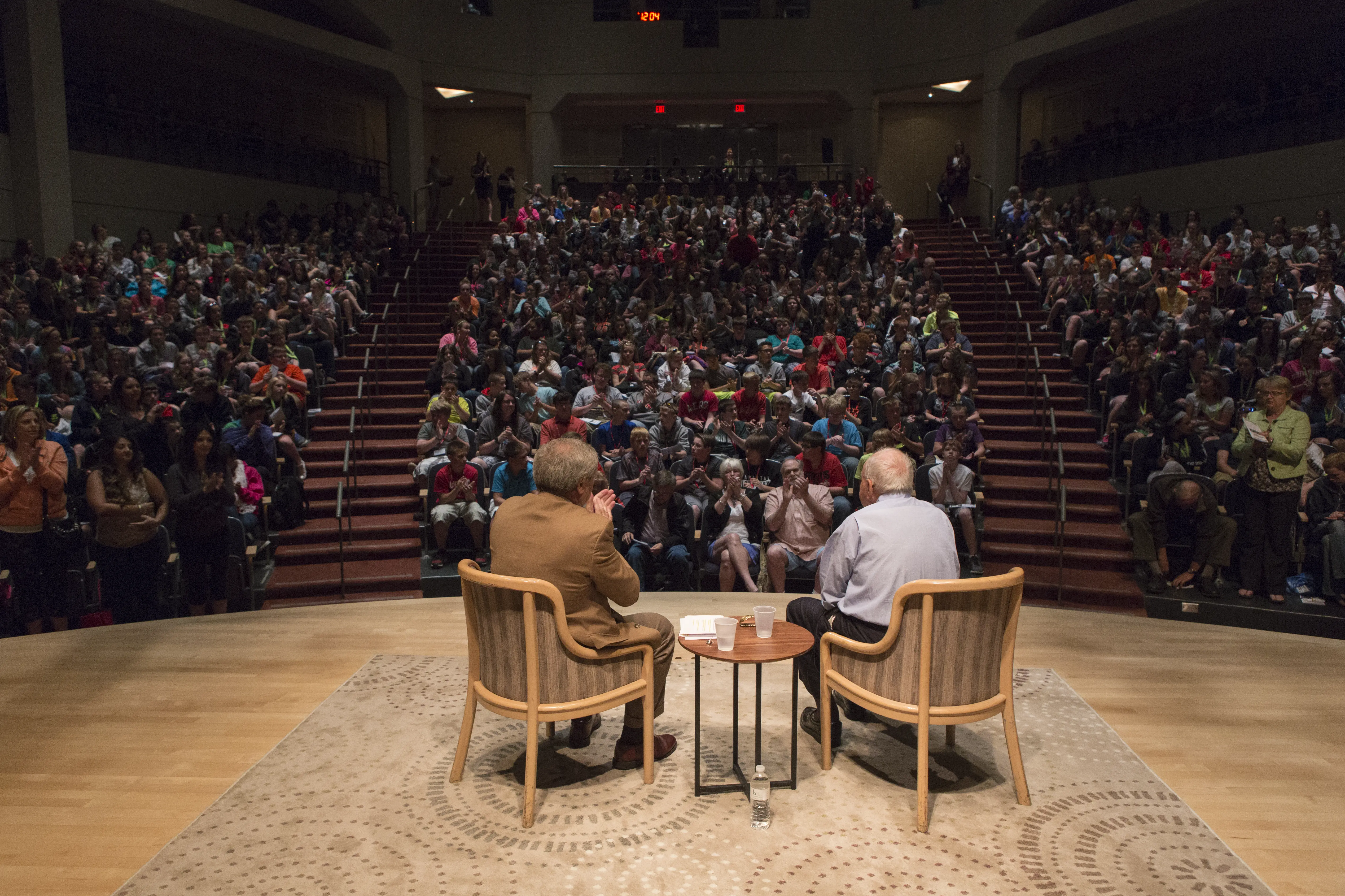 An entire auditorium of people observing two speakers