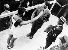 Un atleta saluda a Hitler durante una demostración deportiva en el Saarland, mientras Hans von Tschammer und Osten, director de la Oficina de Deportes del Reich, los observa. Dicha oficina fiscalizaba al Comité Olímpico de Alemania. En abril de 1933, ordenó la implementación de una política "sólo para arios" en todas las organizaciones atléticas alemanas. 1934.