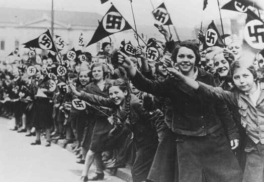 Members of the League of German Girls wave Nazi flags in support of the German annexation of Austria. Vienna, Austria, March 1938.