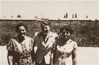 A woman (right) imprisoned in the Gurs camp stands...