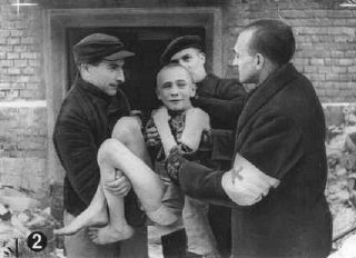 解放直後、収容所の宿舎からソ連の救急隊員に抱えられて出てきた衰弱した子供。