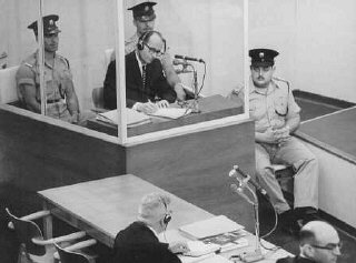 El acusado Adolf Eichmann toma notas durante su proceso...