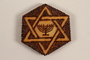 Small hexagonal wooden tile with a Star of David and menorah made by a former Jewish Czech inmate