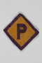 Forced labor badge, yellow with a purple P, worn by a Polish Catholic kidnapped into forced labor service