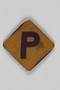 Forced labor badge, yellow with a purple P, worn by a Polish Jewish woman in hiding as a Catholic
