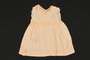 Child's peach silk sleeveless dress with embroidered flowers brought to the US by a Jewish family fleeing German occupied Poland