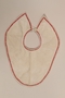 White baby's bib with red trim worn by a Jewish infant while living in hiding