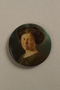 Button with a portrait of young woman with dark hair