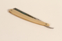 Straight razor with an offwhite plastic handle used by a Polish Jewish refugee conscripted as a shoemaker by the Soviet Army