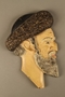 Painted metal wall bust of a sneering Jewish man in a shtreimel