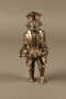 Metal figurine of a Jewish man carrying a tray with a suckling piglet