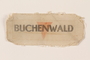 Cloth patch printed Buchenwald over a red inverted triangle worn by a German Jewish man