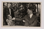 Cigarette card photo of Hitler greeting a young girl and her grandfather