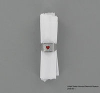 2006.467.1, ring with heart made from spoon, Solomon Goldstein Collection
Ring with a red heart and inmate numbers made from a spoon in a concentration camp

Click to enlarge