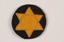 Badge with a yellow Star of David on a black circle worn by a Romanian Jewish woman
