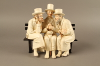 2016.184.103_a-b front
White painted white ceramic group of 3 Jews on a bench with their umbrellas

Click to enlarge