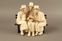 White painted white ceramic group of 3 Jews on a bench with their umbrellas