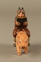 Painted metal figurine of a horned Jewish man with hooves riding a pig