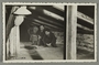 Postcard photo of a family in their wartime attic hiding place