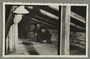 Postcard photo of a family looking at their wartime attic hiding place
