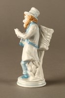 2016.184.589.2 left side
White porcelain match holder depicting a stereotypical Jewish peddler

Click to enlarge