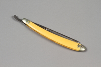 2017.263.6 a side a
Straight razor with yellow plastic handle

Click to enlarge